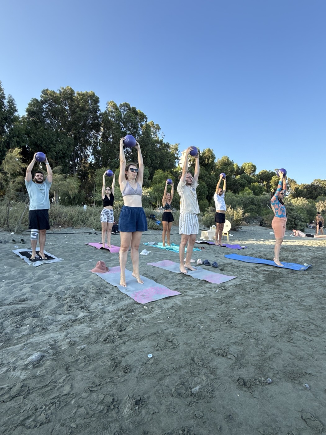 Group Pilates class with balls on the beach